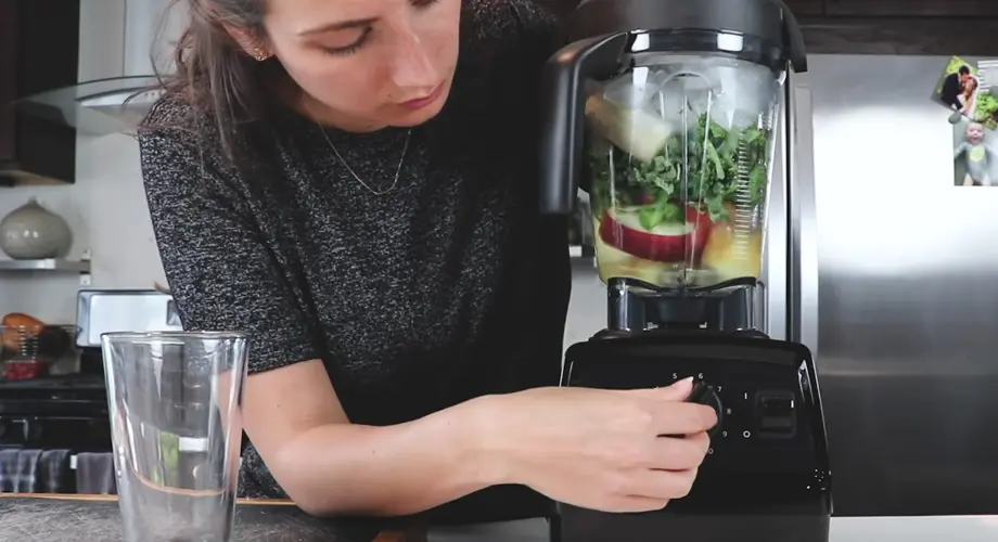 Person using Blender in Kitchen